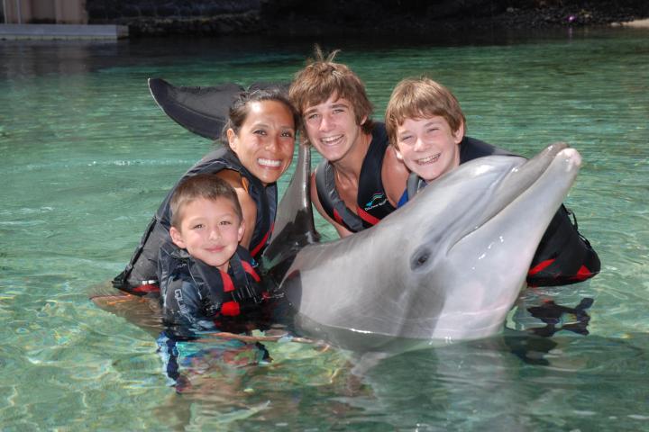 A family wearing wetsuits having a dolphin tour experience.
