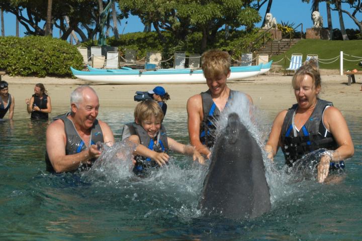 A family wearing wetsuits having a dolphin tour experience.