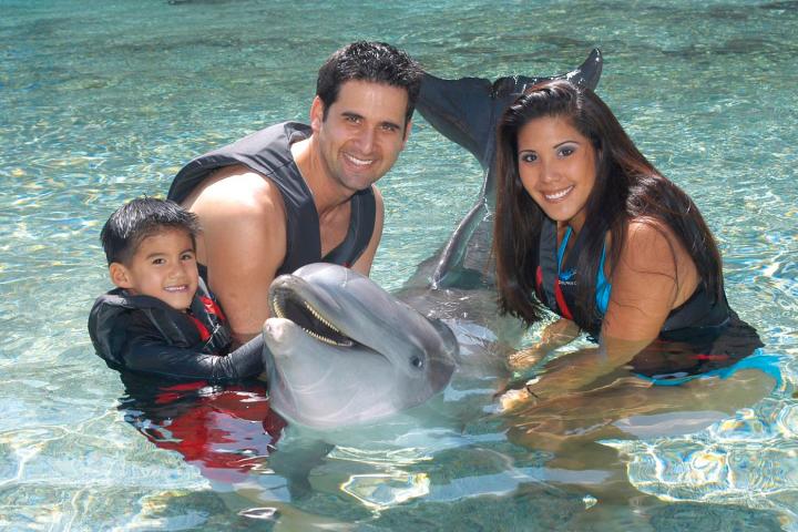 A family wearing wetsuits having a dolphin tour experience.