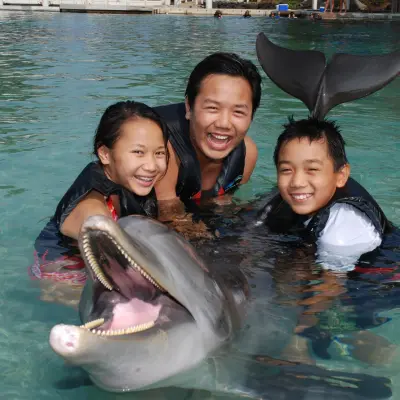 A family wearing wetsuits having a dolphin tour experience.