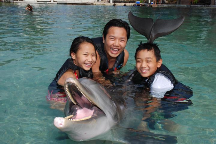 A family wearing wetsuits having a dolphin tour experience.