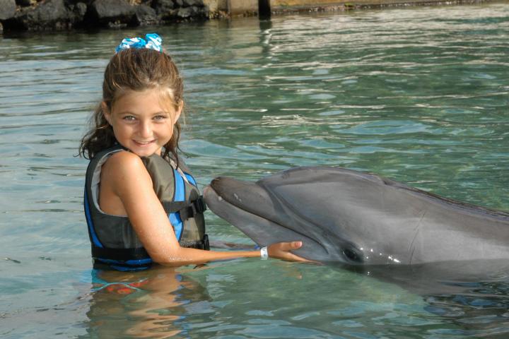 A little girl wearing wetsuit having a dolphin tour experience.