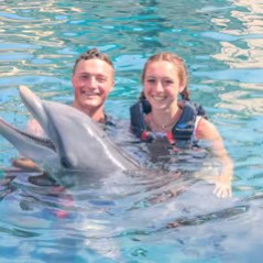 A dolphin interaction of a young couple in the pool.
