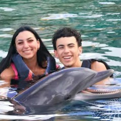A dolphin interaction of a young couple in the pool.