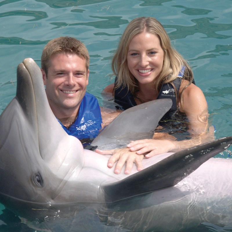 Couple wearing wetsuits on a dolphin experience tour.