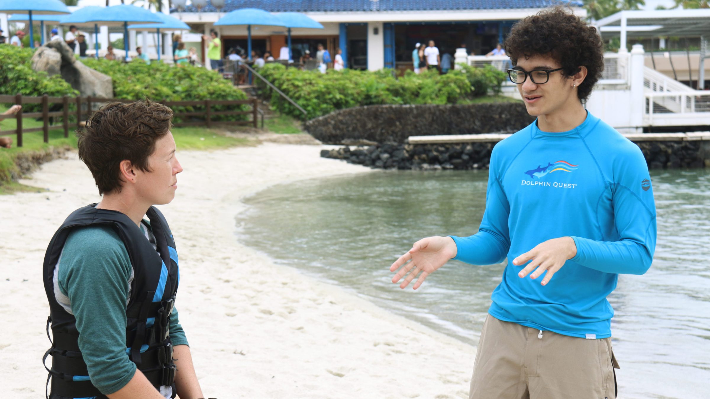 A crew having a discussion with the guest near the beach.