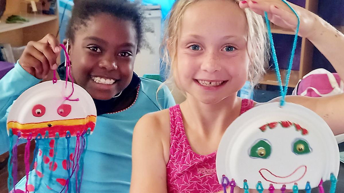 Two little girl holding a hand made jelly fish.