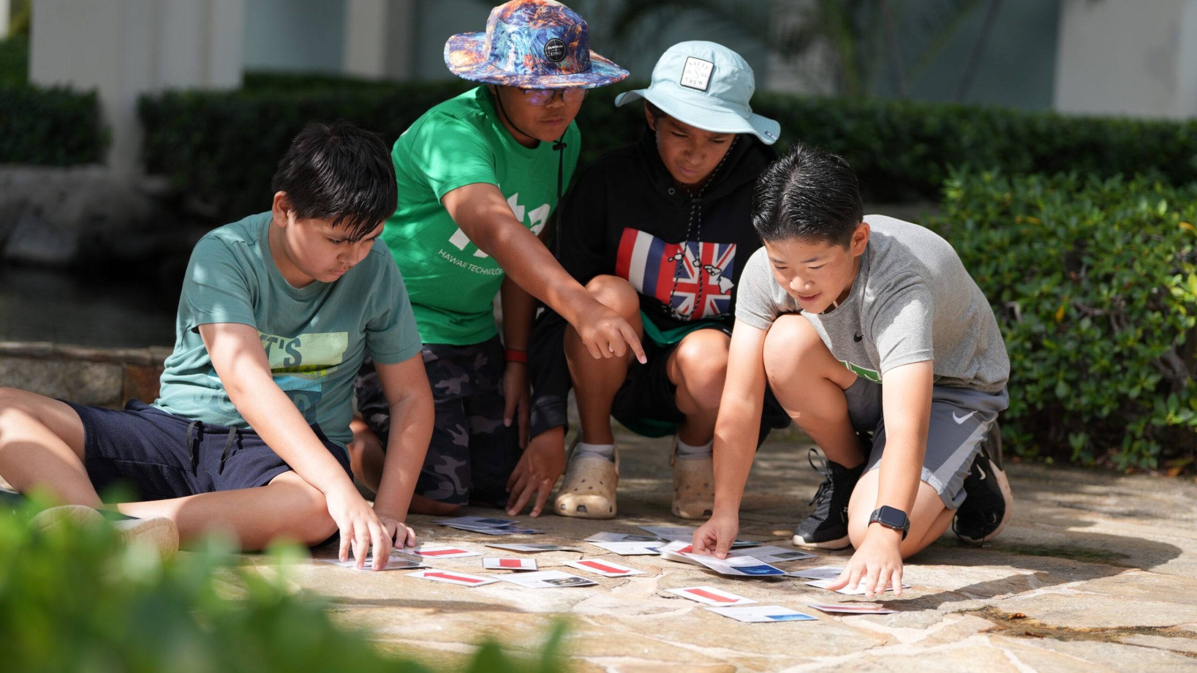 A group of young children arranging photos in the ground.