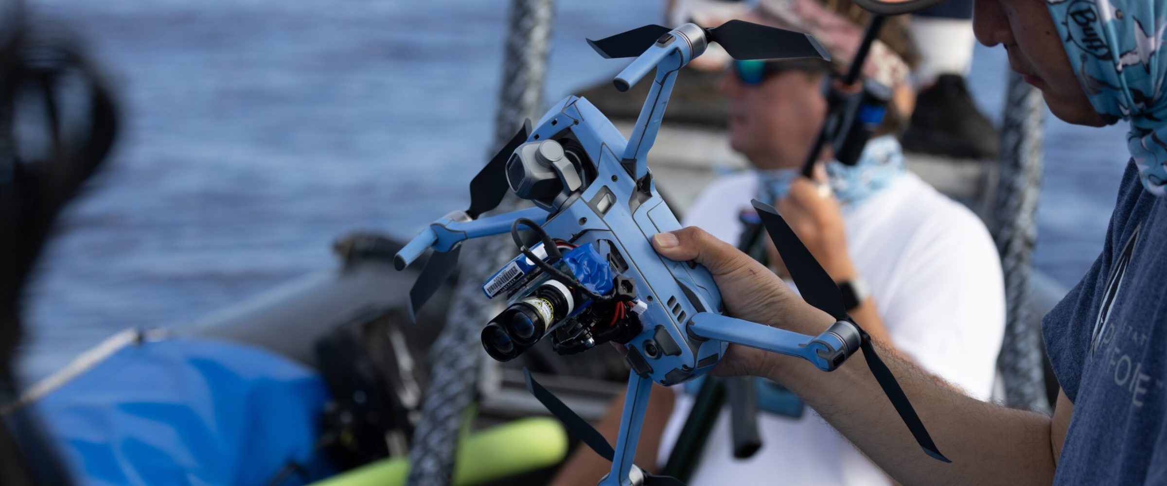A man holding a drone on a boat. A man holding a drone on a boat.