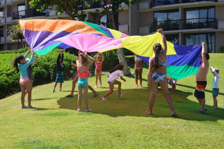 a young girl flying a kite in a field